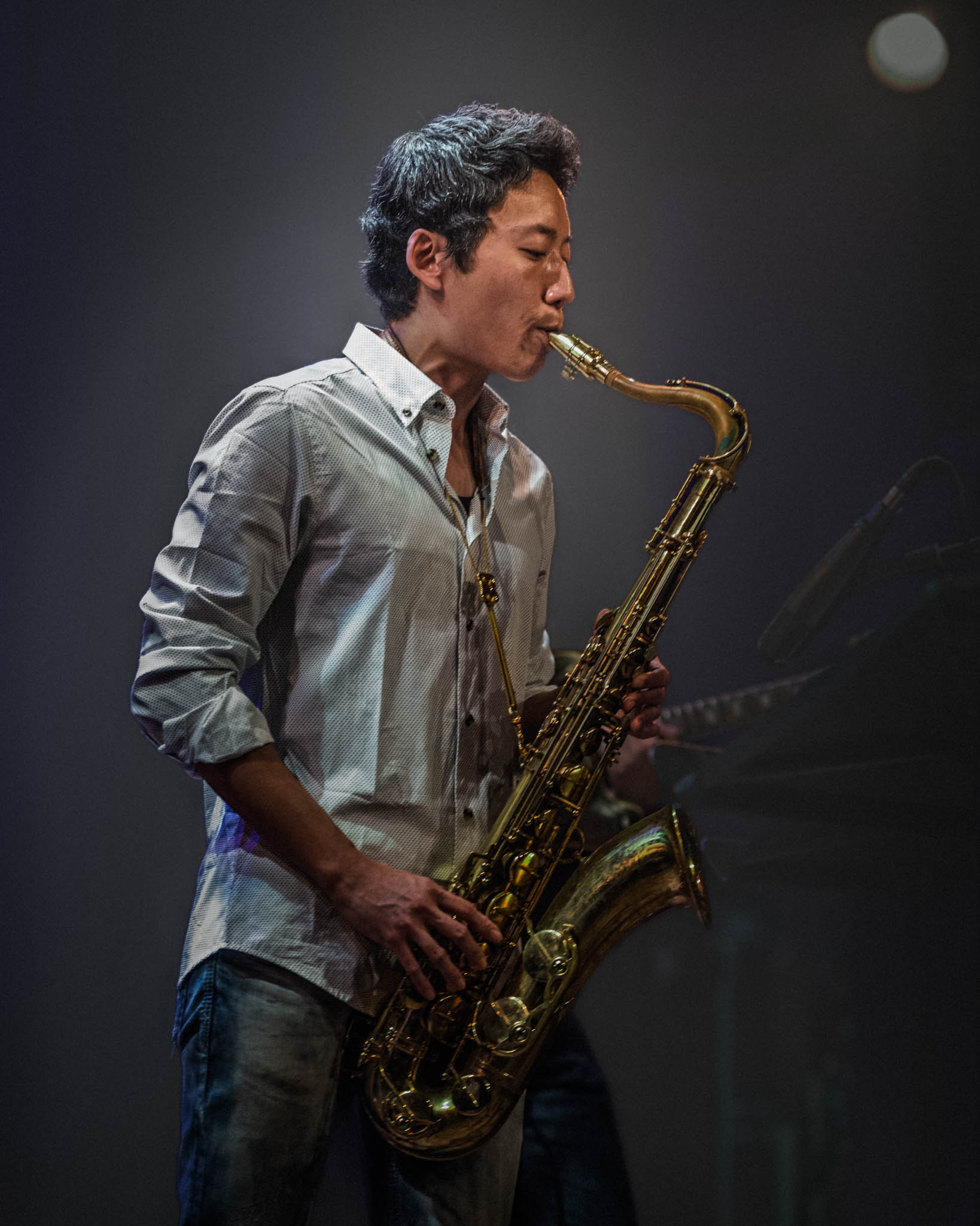 Jazz Saxofonist auf der Bühne, vor dunklem Hintergrund